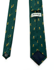 Green polyester tie with gold skull and crossbones pattern on forest green background by Crossrow London