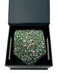 Deep green cotton tie with white blossoms and red clover pattern in a black gift box