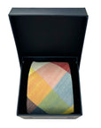 Camden Block tie in vibrant ochre, rust, sage, and blue patchwork pattern, neatly presented in a black box.