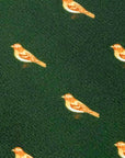 Close-up of Birdwatcher's Haven polyester tie with small orange birds on forest green background fabric texture