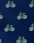 Close-up of navy polyester tie with detailed light blue and yellow bicycle pattern design