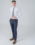 Man wearing a white shirt and navy trousers styled with a green floral patterned Clover Grove cotton tie
