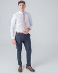 Man wearing Cotswold Bloom tie with floral pattern in pink, orange, and yellow on beige background with formal outfit.