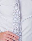 English Garden Mist - Cotton Tie with floral vines in blue and lilac on a soft neutral background worn on white shirt