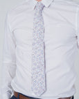 English Garden Mist - Cotton Tie with delicate blue and lilac floral pattern on soft neutral background, styled with white shirt.