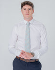 Man wearing white shirt and Golden Lily Sage cotton tie with floral pattern, styled for formal or casual wear
