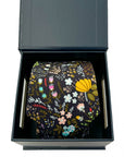 Floral cotton tie with mustard, lilac, blue, and blush blooms on black, packed in a sleek gift box.