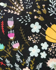 Close-up of Briar Moon cotton tie fabric with colorful floral patterns on a black background