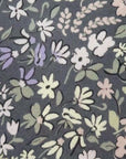 Close-up of Blossom Field Cotton Tie showing stone-grey fabric with pastel lavender, blush, and sage floral pattern.