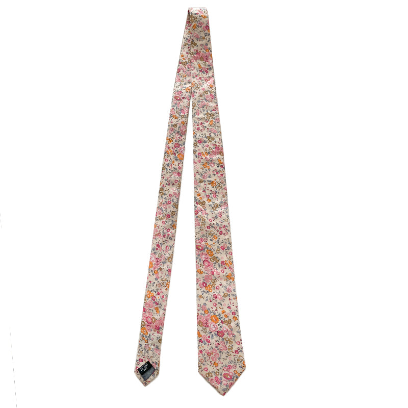 Cotswold Bloom tie with a vibrant floral pattern in pink, orange, and yellow on a beige background