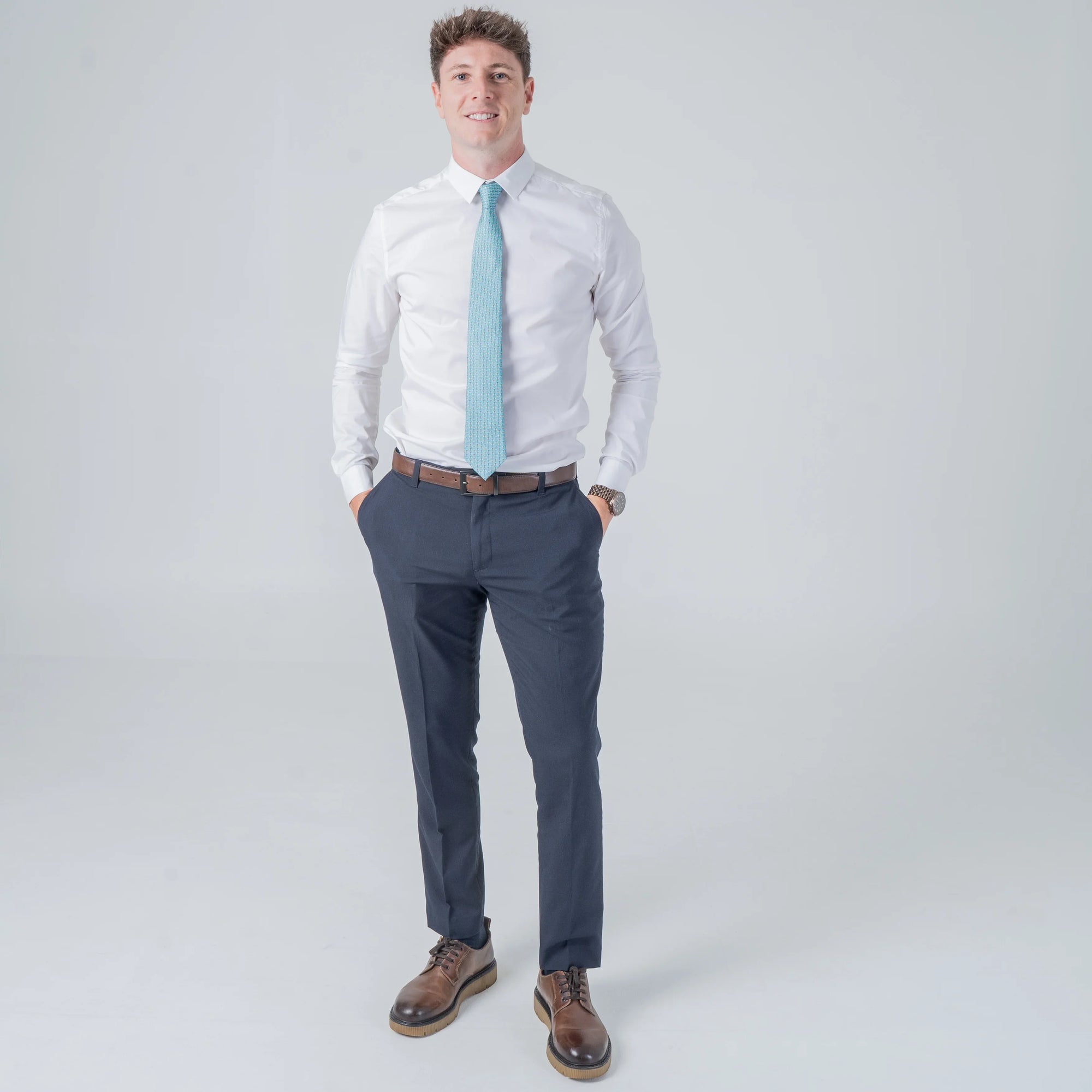Man wearing Dragonfly Dance - Silk Tie in teal with dragonfly pattern paired with white shirt and navy pants