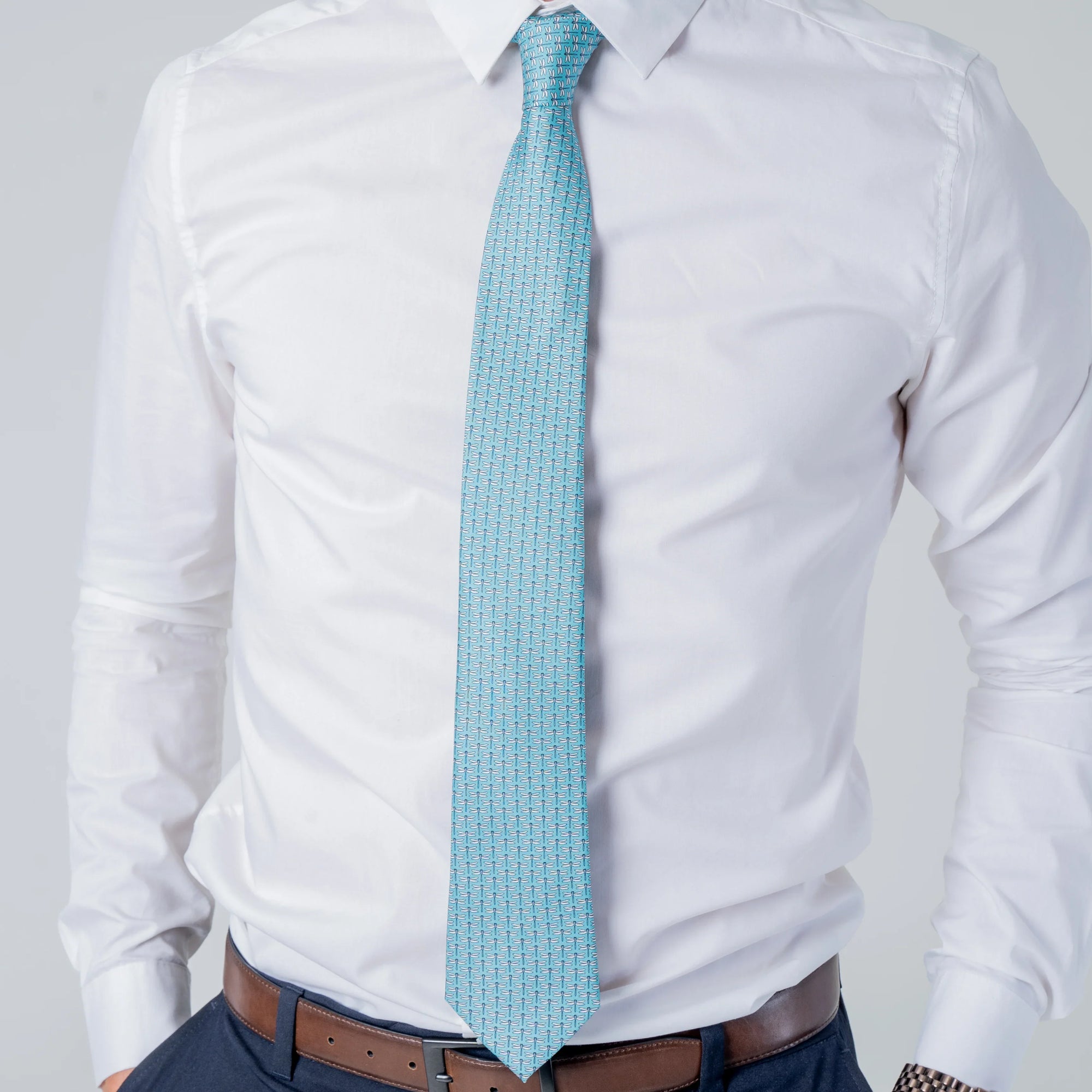 Dragonfly Dance - Silk Tie in vibrant teal with delicate dragonfly pattern worn with white shirt and navy pants.
